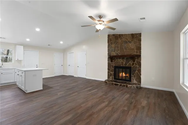 a view of an empty room with a fireplace and wooden floor
