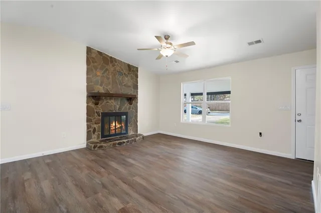 a view of an empty room with a fireplace and a window