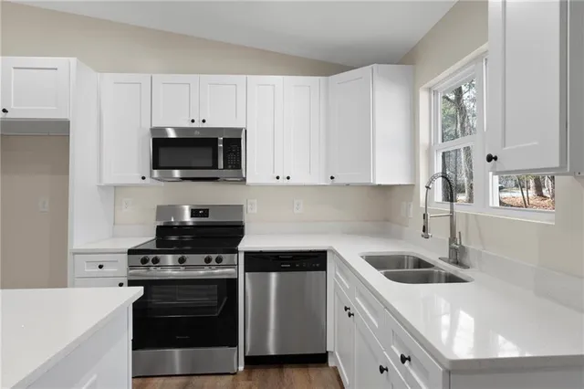 a kitchen with cabinets a sink and stainless steel appliances