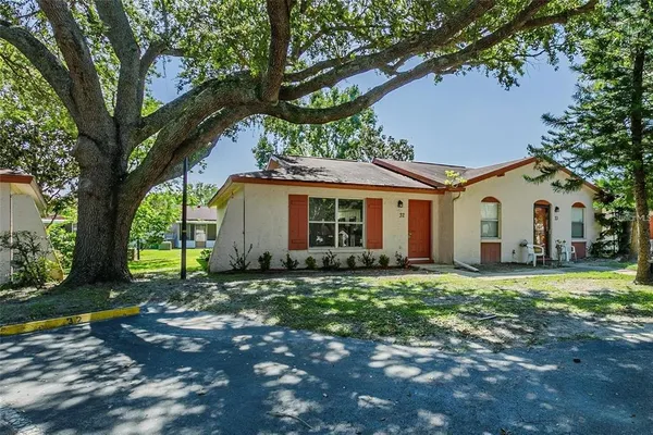 a front view of a house with a garden and trees