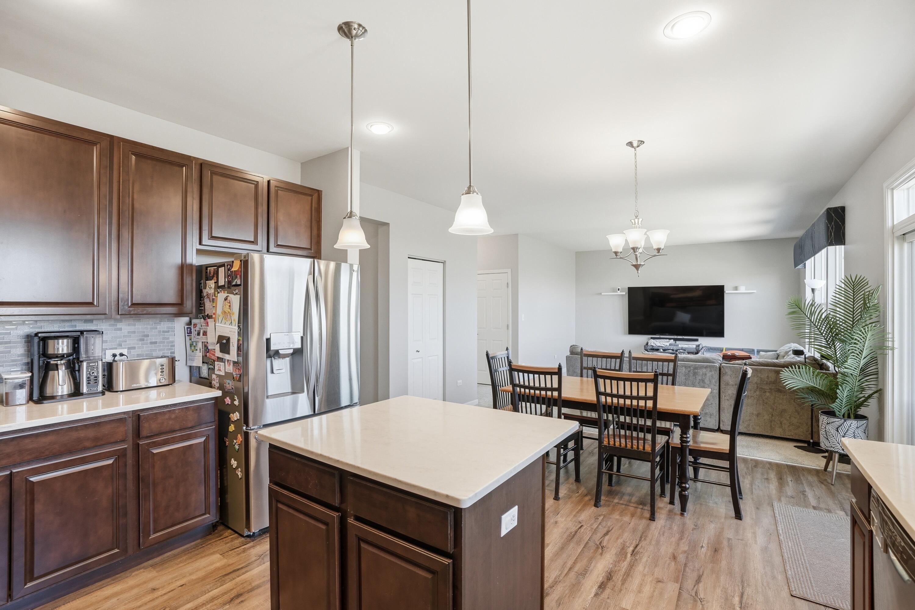 10322 Adler Cove St. John, IN 46373 - Photo 10 of 26 a kitchen with a table chairs refrigerator and microwave