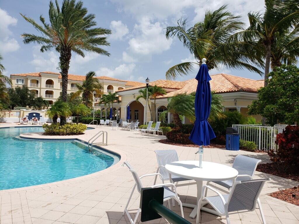 31 Harbour Isle Drive West, Unit 303 Fort Pierce, FL 34949 - Photo 22 of 31 a view of a patio with swimming pool table and chairs