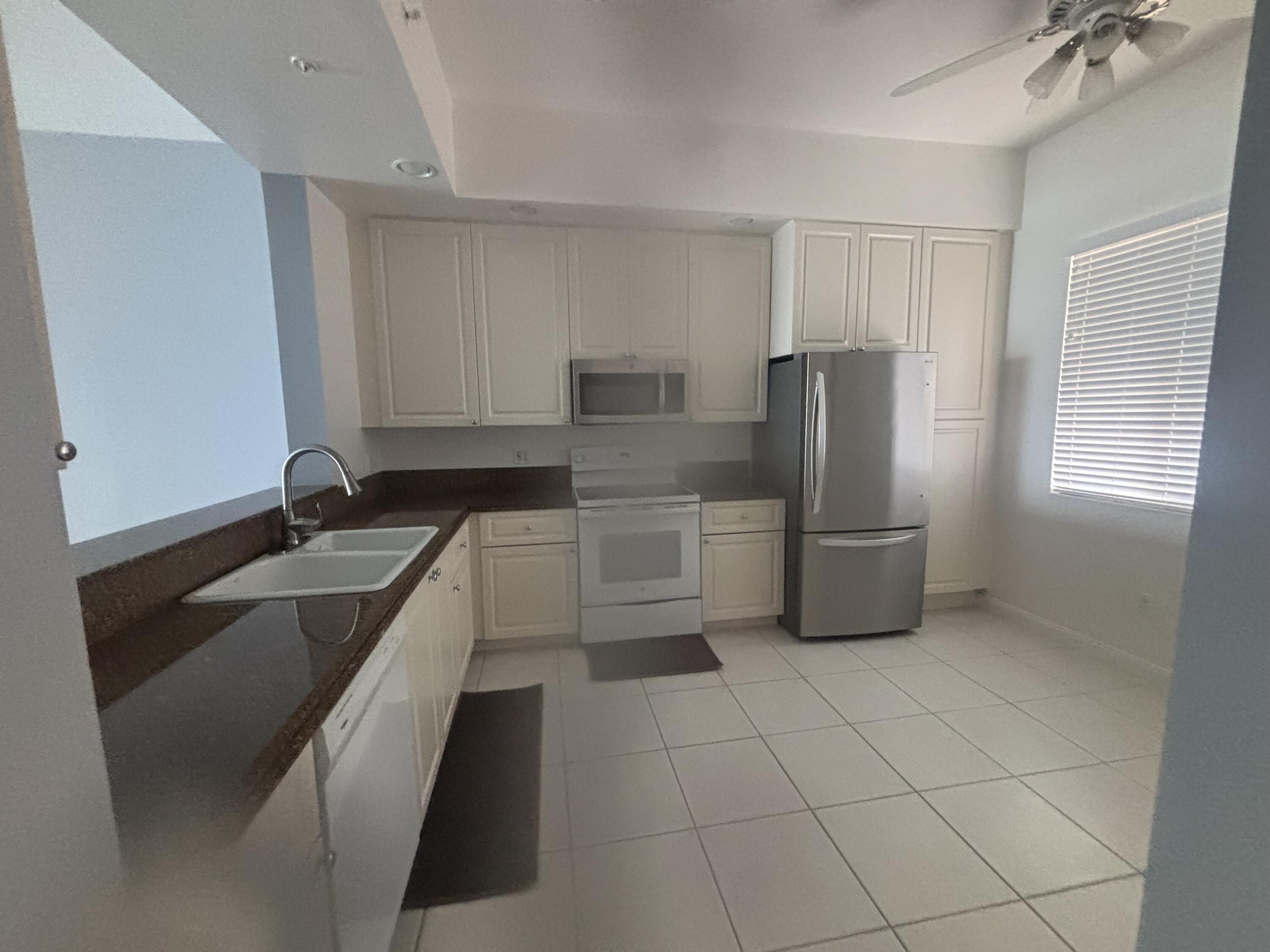 31 Harbour Isle Drive West, Unit 303 Fort Pierce, FL 34949 - Photo 3 of 31 a kitchen with stainless steel appliances a sink stove and refrigerator