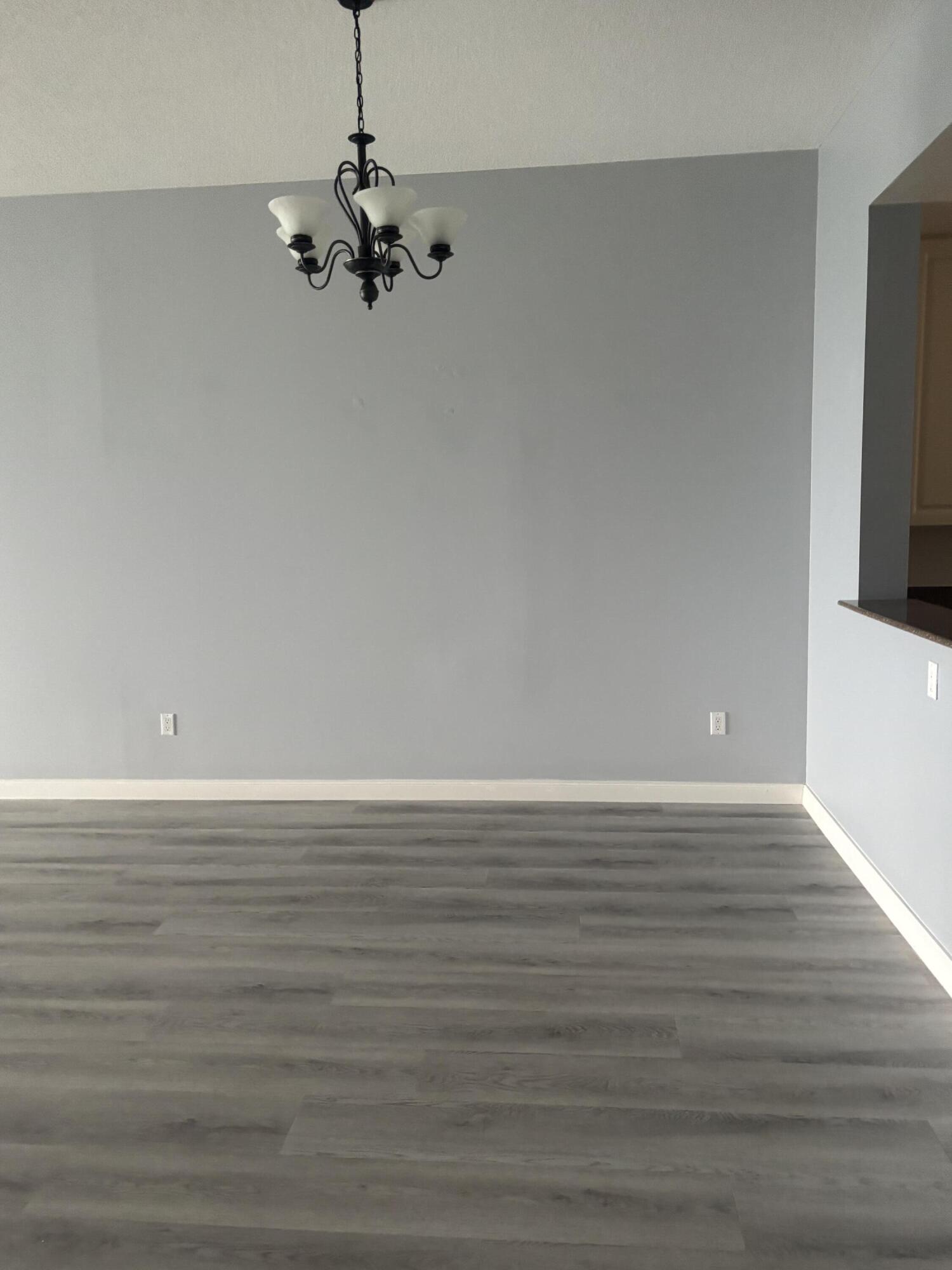 31 Harbour Isle Drive West, Unit 303 Fort Pierce, FL 34949 - Photo 6 of 31 a view of a room with wooden floor and chandelier