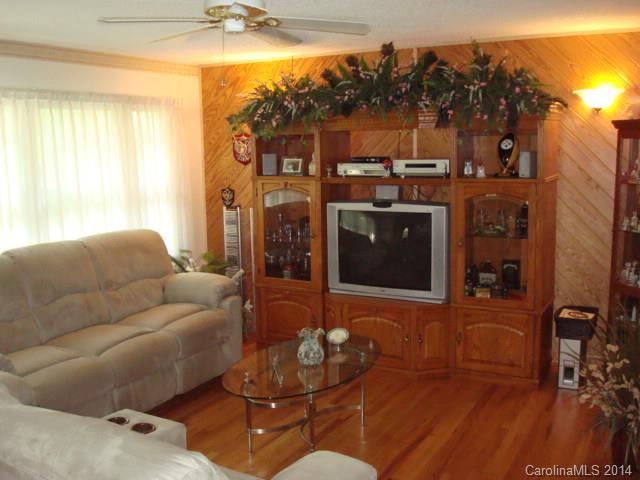 3205 Puetts Chapel Road Dallas, NC 28034 - Photo 6 of 24 a living room with furniture a flat screen tv and a floor to ceiling window