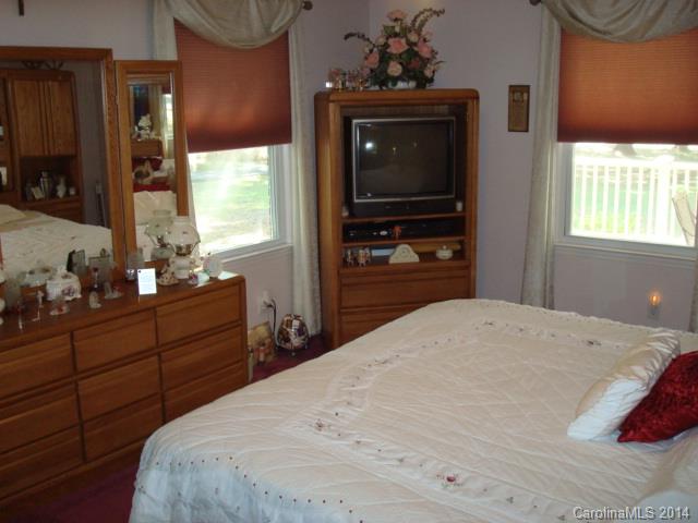 3205 Puetts Chapel Road Dallas, NC 28034 - Photo 10 of 24 a bedroom with a bed and a flat tv screen on dresser