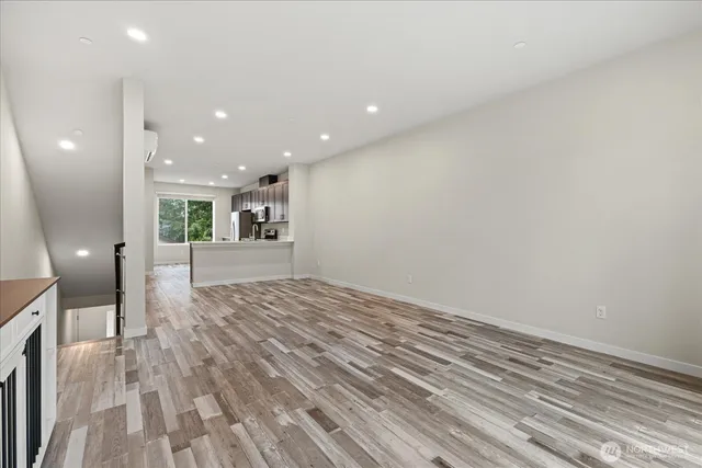 a view of a big room with wooden floor and windows