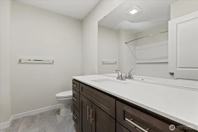 a bathroom with a granite countertop sink a toilet and a mirror