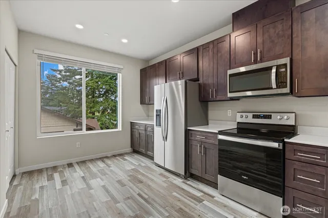 a kitchen with granite countertop wooden cabinets a refrigerator and a sink