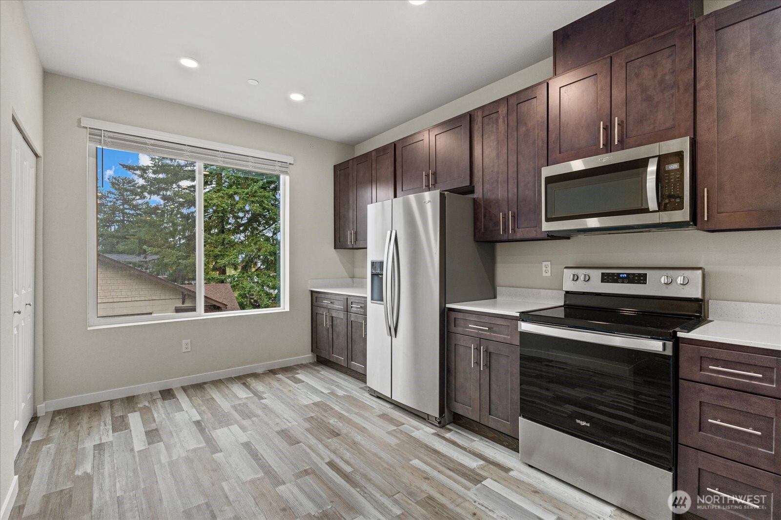 1831 100th Street Southwest, Unit B Everett, WA 98204 - Photo 6 of 27 a kitchen with granite countertop wooden cabinets a refrigerator and a sink
