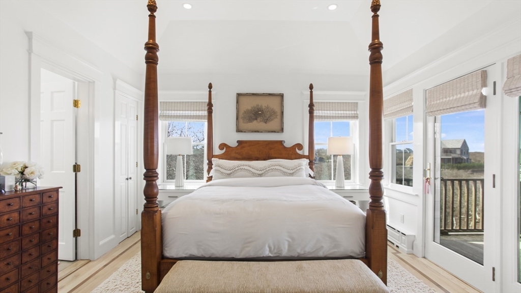 26 Old Tom Nevers Road, Unit 1 Nantucket, MA 02554 - Photo 14 of 31 a bedroom with a large bed and a chandelier