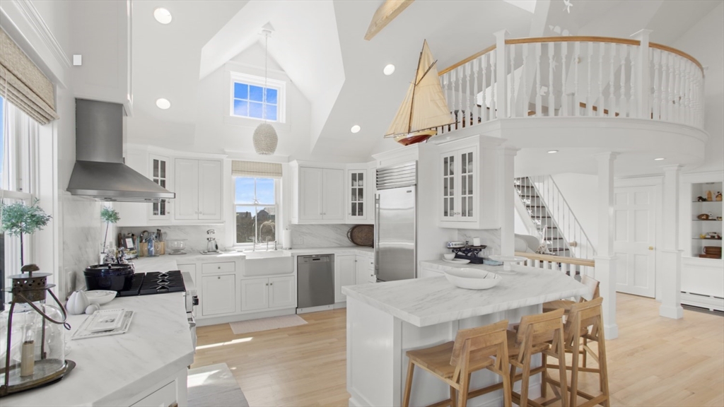 26 Old Tom Nevers Road, Unit 1 Nantucket, MA 02554 - Photo 6 of 31 a kitchen with stainless steel appliances kitchen island granite countertop a sink and cabinets