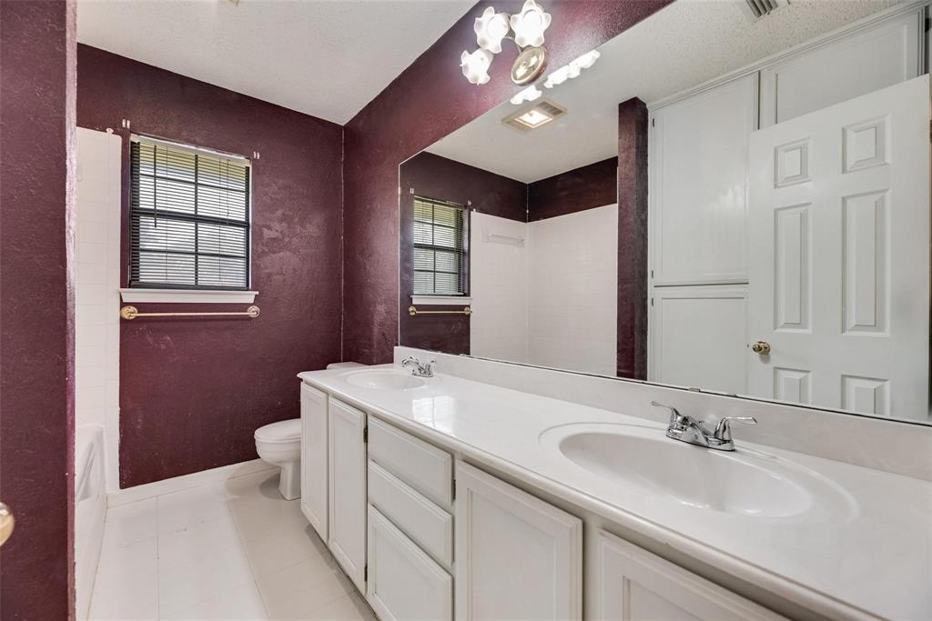 918 Prairie Avenue Cleburne, TX 76033 - Photo 17 of 25 a bathroom with a sink double vanity and a mirror