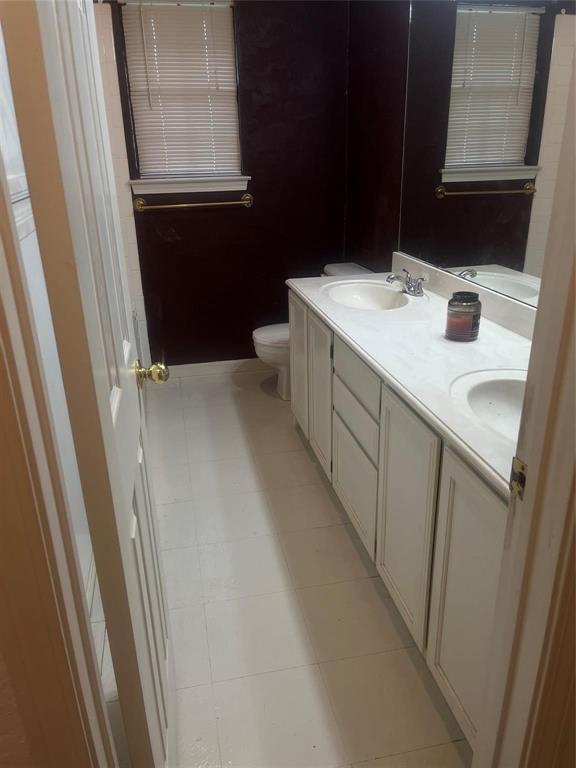 918 Prairie Avenue Cleburne, TX 76033 - Photo 21 of 25 a bathroom with a sink a toilet and a mirror