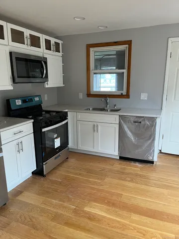 a kitchen with stainless steel appliances granite countertop a sink and a stove top oven