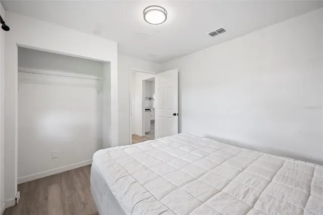 a view of a bedroom with wooden floor