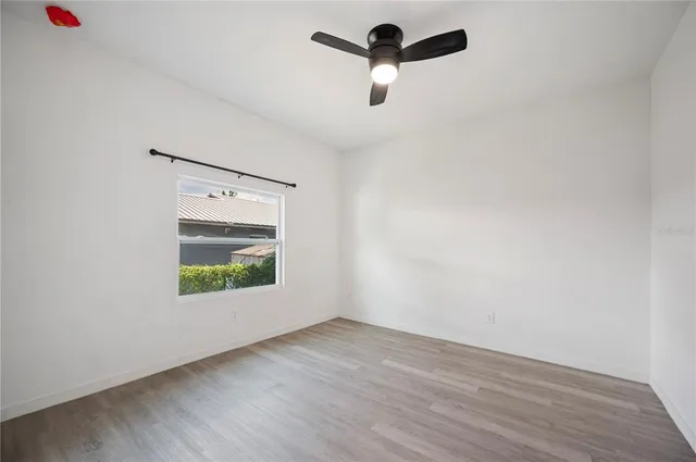 an empty room with a window and a ceiling fan