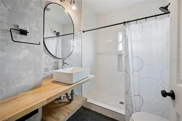 a bathroom with a sink and mirror with bathtub