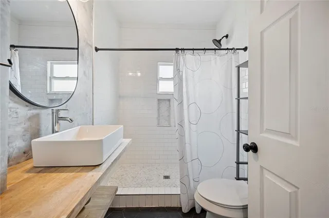 a bathroom with a sink a toilet and shower