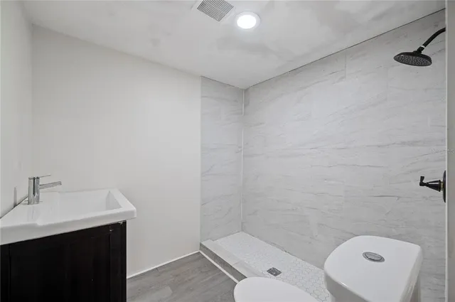 a bathroom with a toilet a sink and mirror