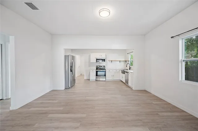 a view of a kitchen with a refrigerator and a window