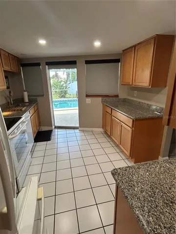 a kitchen with stainless steel appliances granite countertop a refrigerator a sink a stove a microwave and island