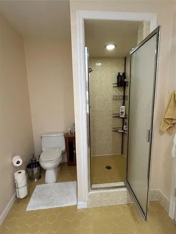 a bathroom with a granite countertop shower and a toilet