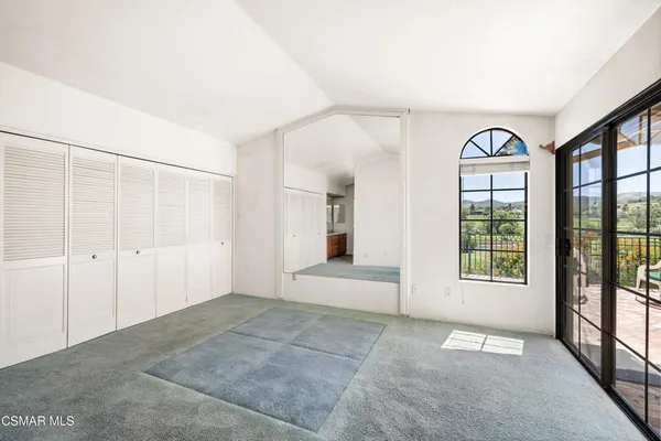 a view of an empty room with window and cabinet