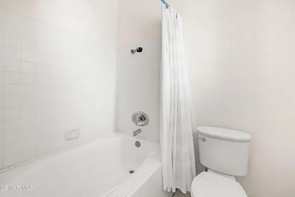 a white toilet sitting next to a bath tub