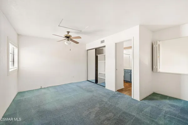 a view of a room with a ceiling fan and window