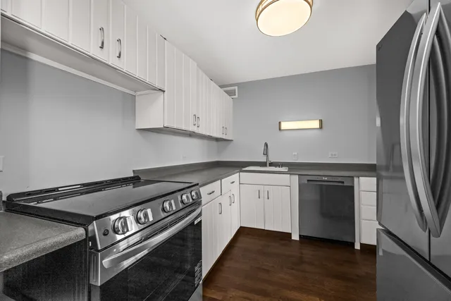 a kitchen with stainless steel appliances granite countertop a stove a sink and a refrigerator
