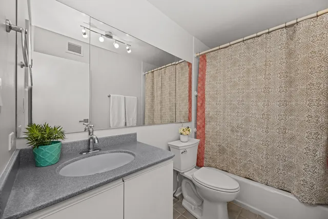 a bathroom with a granite countertop sink a toilet and a mirror