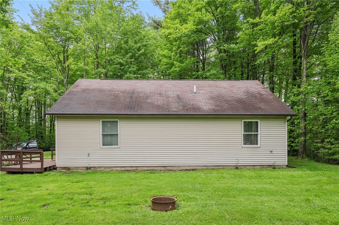 2490 Dodgeville Road Rome, OH 44085 - Photo 26 of 42 View of home's exterior with a fire pit, a wooden deck, a lawn, and roof with shingles