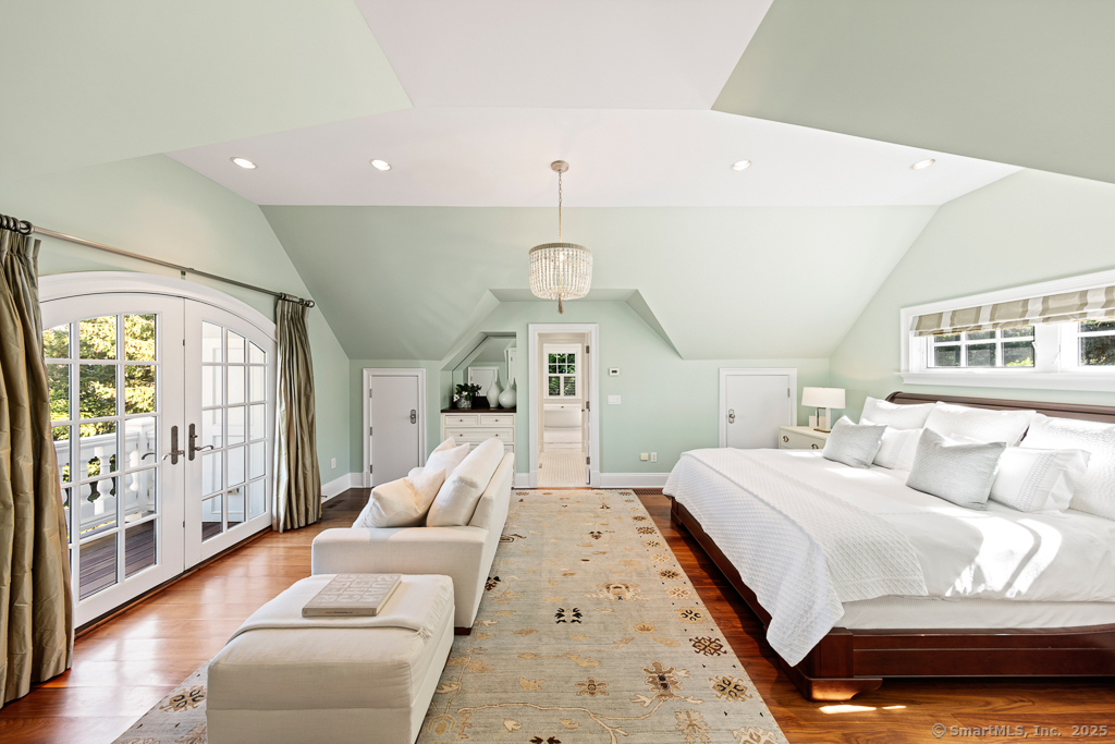 260 Hillspoint Road Westport, CT 06880 - Photo 21 of 40 a bedroom with a large bed and a chandelier