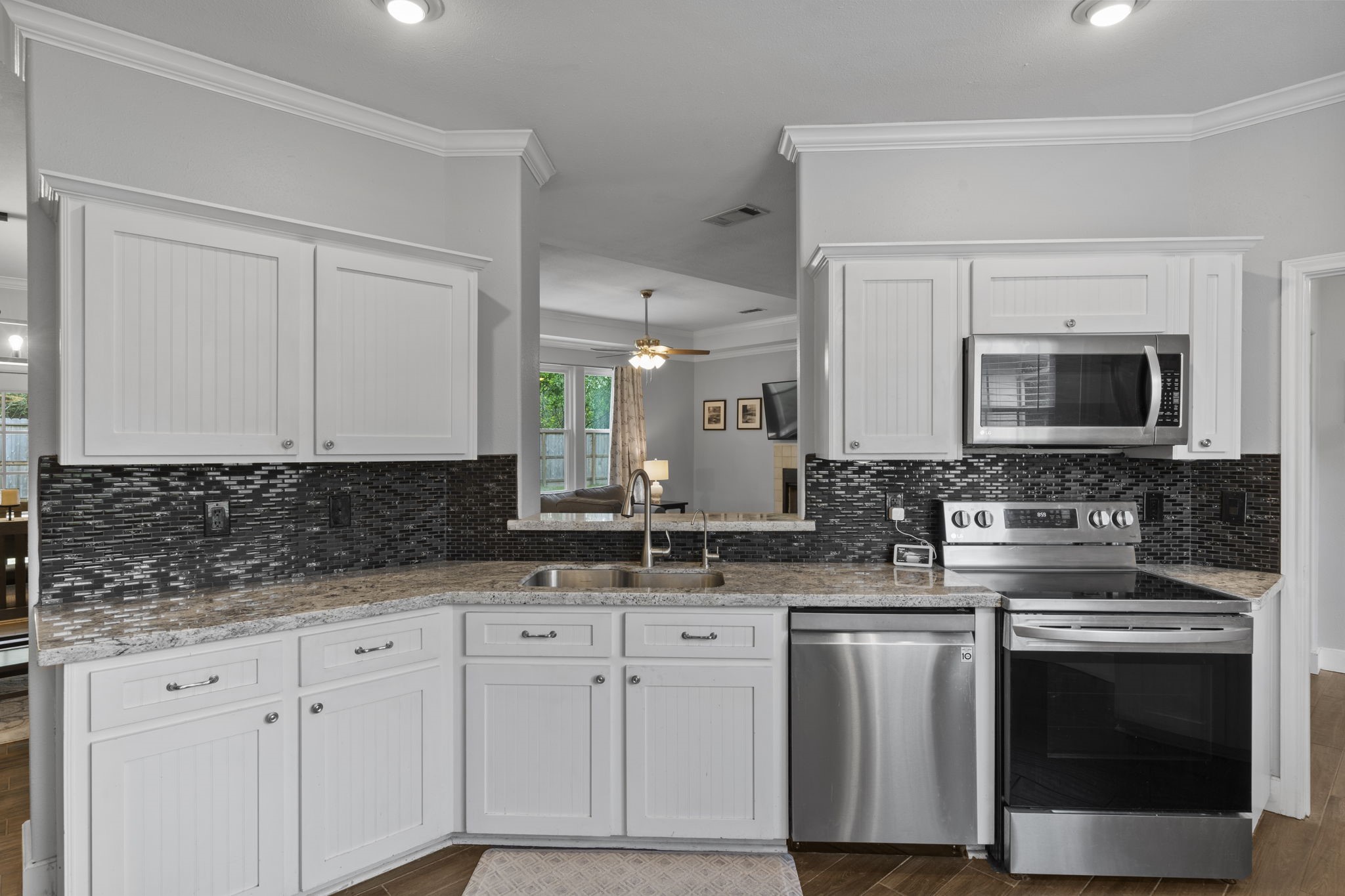 23200 Baneberry Road Magnolia, TX 77355 - Photo 13 of 39 a kitchen with white cabinets and stainless steel appliances