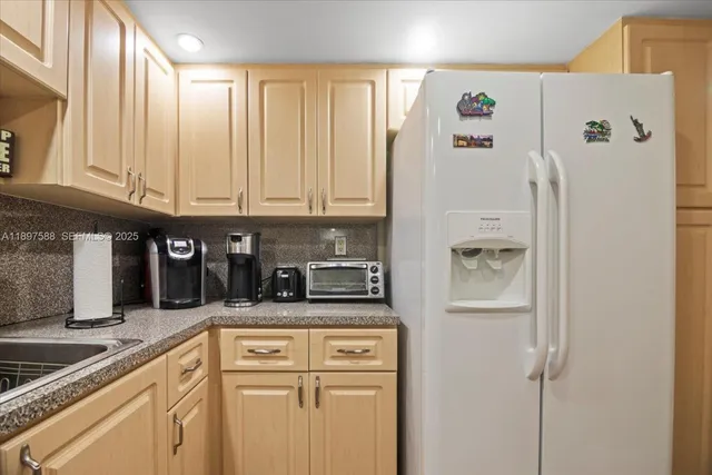 a kitchen with stainless steel appliances granite countertop a refrigerator and a stove