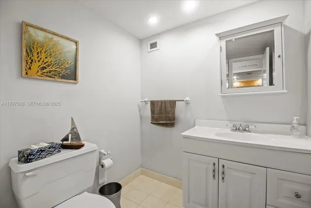 a bathroom with a toilet sink vanity and mirror