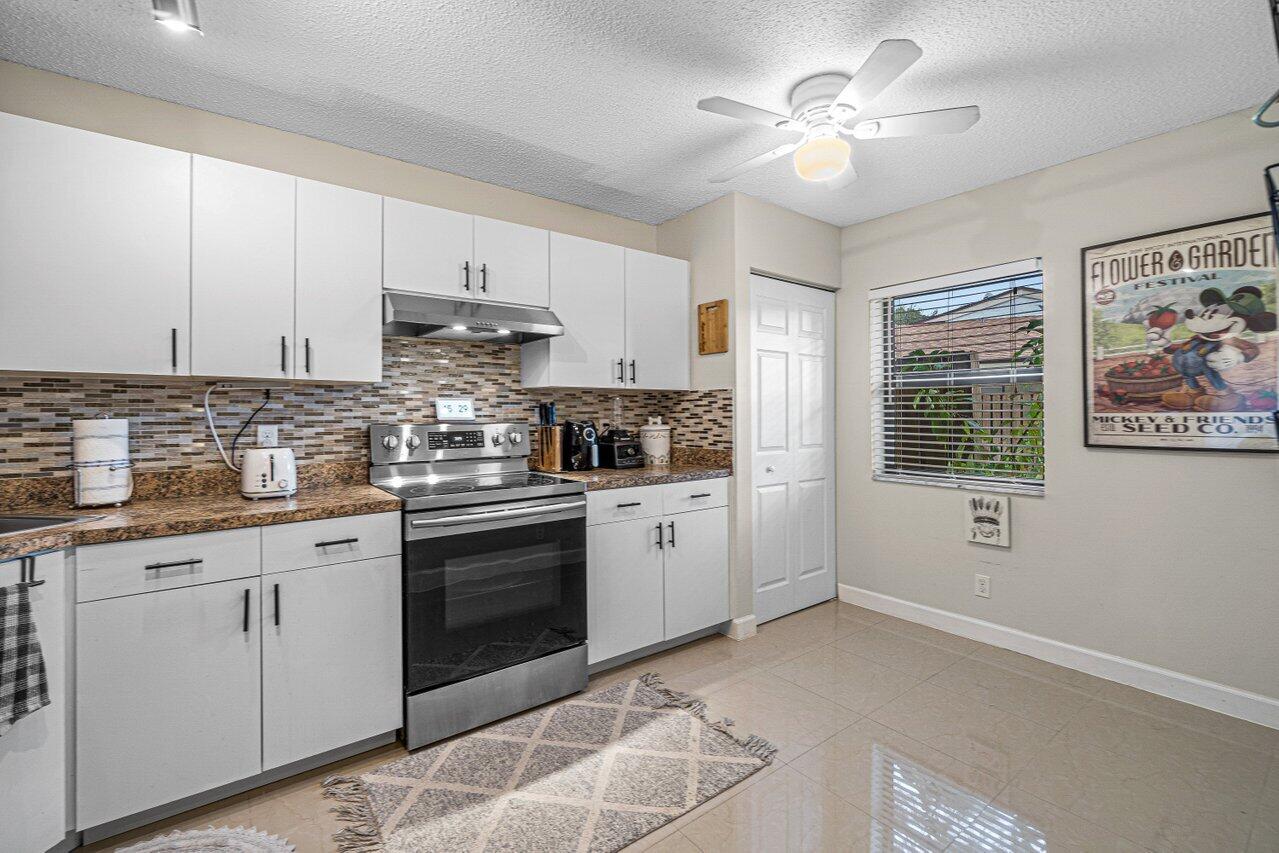 241 Meadows Drive Boynton Beach, FL 33436 - Photo 11 of 24 a kitchen with cabinets stainless steel appliances and a window