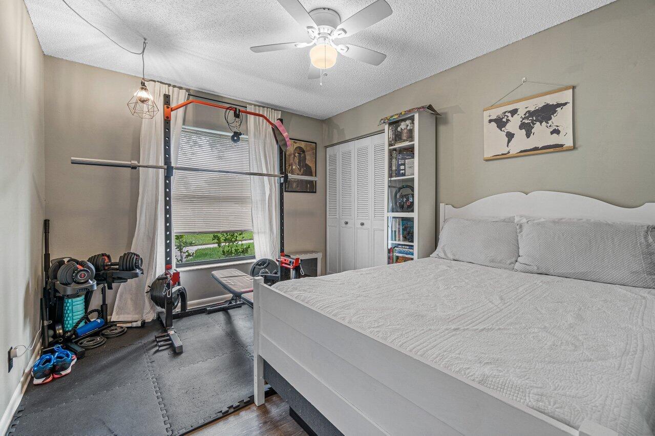 241 Meadows Drive Boynton Beach, FL 33436 - Photo 18 of 24 a bedroom with a bed a table and a chandelier