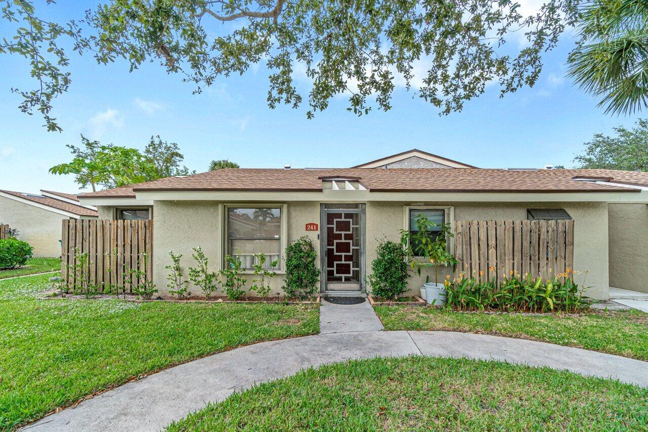 241 Meadows Drive Boynton Beach, FL 33436 - Photo 2 of 24 a front view of a house with garden