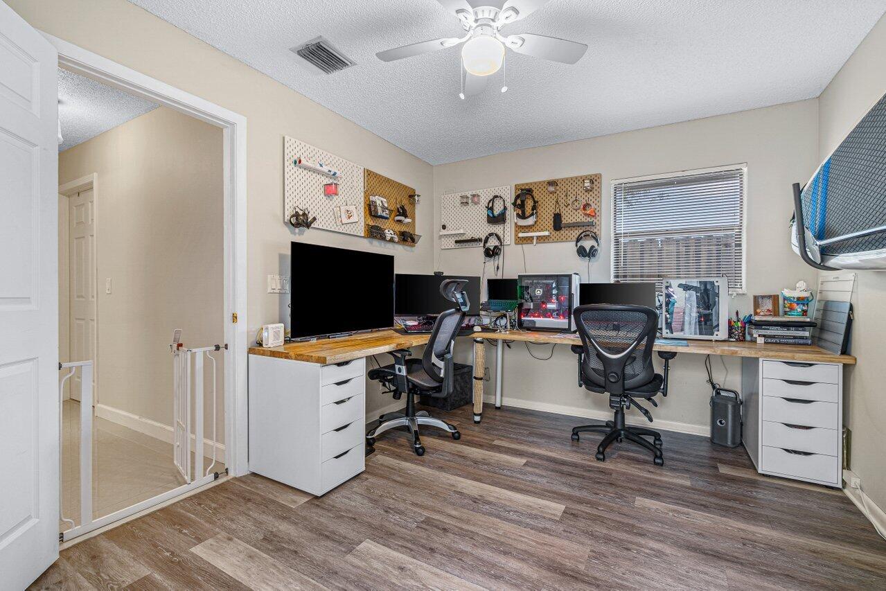 241 Meadows Drive Boynton Beach, FL 33436 - Photo 21 of 24 a view of a workspace with furniture and a ceiling fan