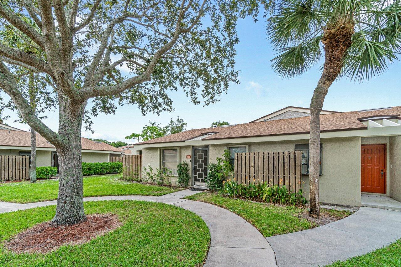 241 Meadows Drive Boynton Beach, FL 33436 - Photo 4 of 24 a view of a house with a big yard plants and palm trees
