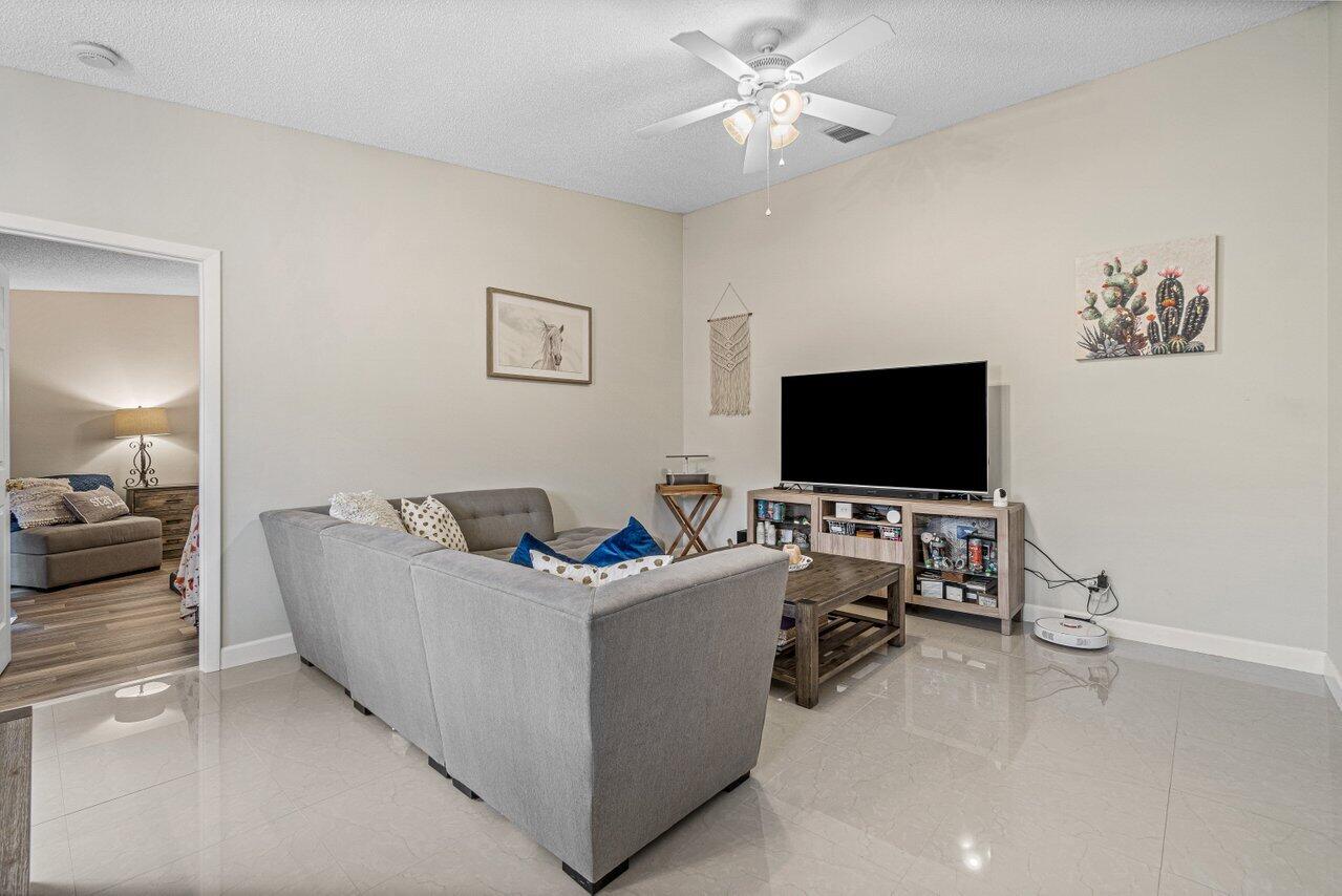 241 Meadows Drive Boynton Beach, FL 33436 - Photo 9 of 24 a living room with furniture and a flat screen tv