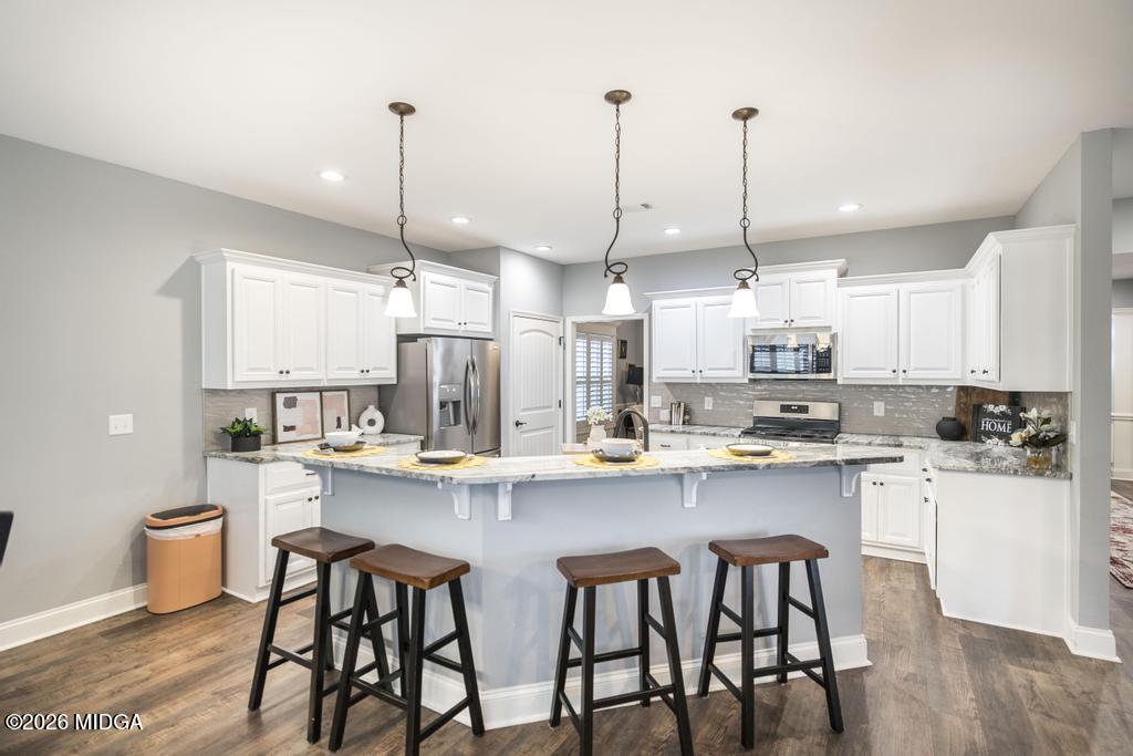 137 Shady Oak Drive Perry, GA 31069 - Photo 18 of 37 a kitchen with stainless steel appliances granite countertop a sink a stove a refrigerator and chairs
