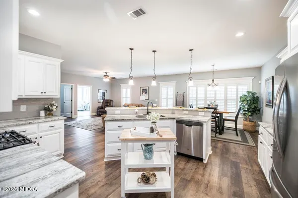 a large kitchen with kitchen island a sink a stove a center island a dining table and chairs