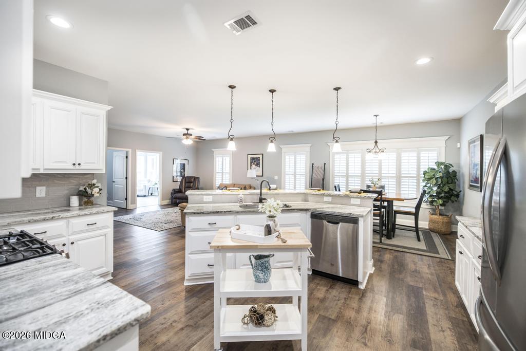 137 Shady Oak Drive Perry, GA 31069 - Photo 20 of 37 a large kitchen with kitchen island a sink a stove a center island a dining table and chairs