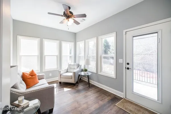 a living room with furniture and a large window with wooden floor
