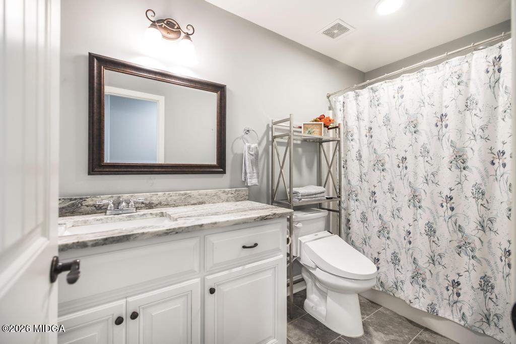 137 Shady Oak Drive Perry, GA 31069 - Photo 32 of 37 a bathroom with a toilet sink vanity and mirror