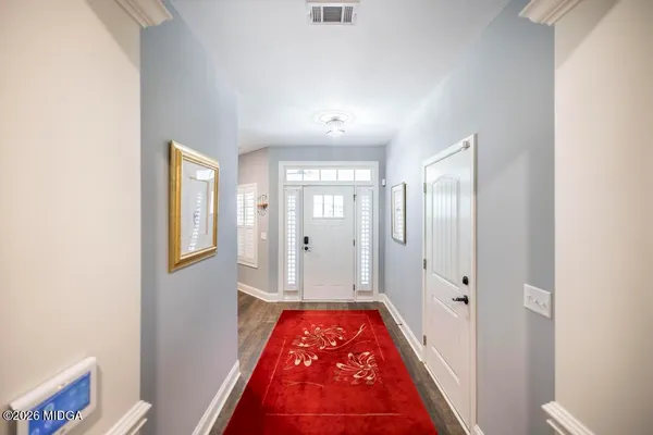 a view of a hallway view with wooden floor and a bathroom
