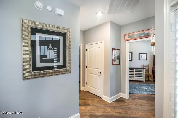 a view of a hallway with wooden floor and a living room